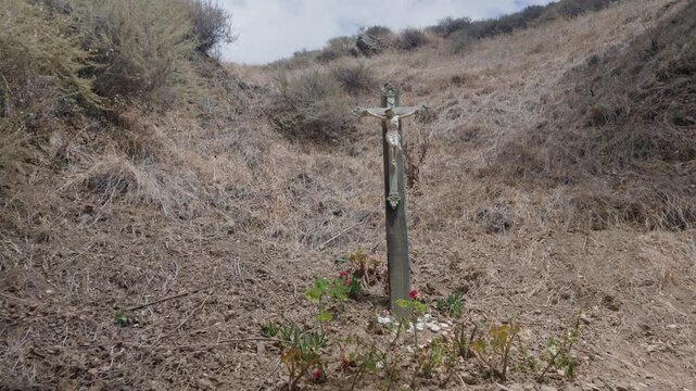 A forward camera move reveals a detailed Jesus Christ cross ornament at the hillside religious attraction.