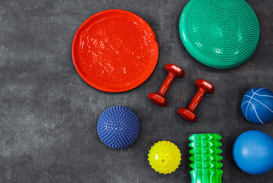 Dumbbells, fitness balls, rollers and sensory balls for physical therapy and rehabilitation in a modern rehabilitation center, top view