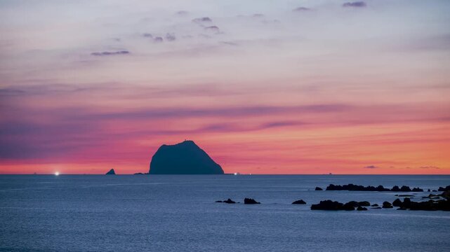Breathtaking sunrise view with a dramatic orange and pink colorful sky over Keelung Islet and the ocean in Taiwan.