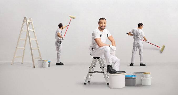 Team of professional painters working and painting a wall