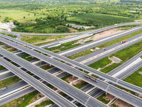 Drone shot a large highway interchange crossing over green farmlands in Thailand