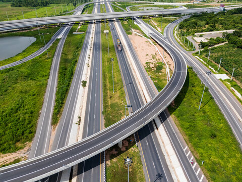 Drone shot a large highway interchange crossing over green farmlands in Thailand