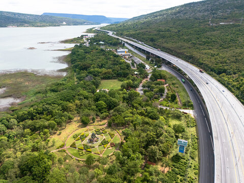 Drone aerial view of Motorway M6 Bang Pa-in&ndash;Nakhon Ratchasima expressway running beside Lam Takhong Reservoir in Nakhon Ratchasima, Thailand under cloudy skies