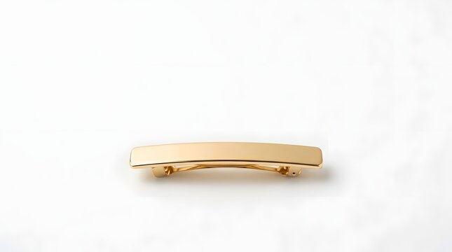 Gold barrette resting on white surface