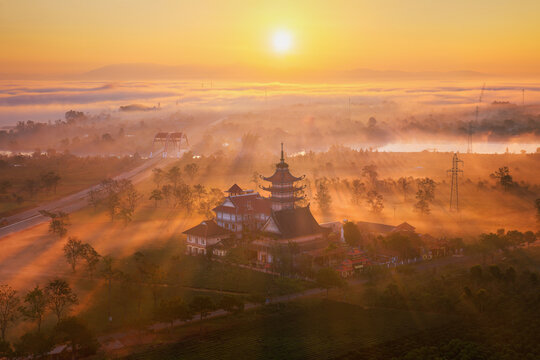 Aerial view of Buu Minh pagoda amidst morning fog and golden sunbeams at sunrise, Gia Lai, Vietnam
