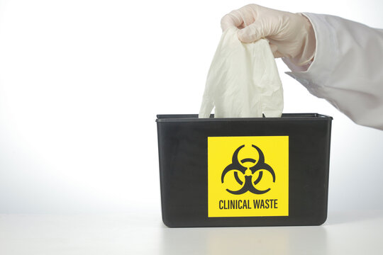 Cautious doctor wears glove during biohazard waste storage disposal ensuring clinical safety when handling hazardous medical material