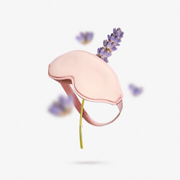 Lavender dried flowers with pink sleep mask flying on light gray background. Creative minimalistic concept of peaceful night routine, sleep quality and relaxation through natural aromatherapy benefits