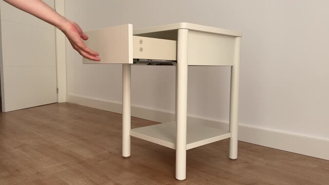 Hand demonstrating a smooth soft-close nightstand drawer, 4K video