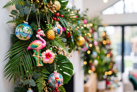 Tropical christmas garland with flamingo and palm ornaments and hibiscus accents for colorful holiday decor background and festive interior display