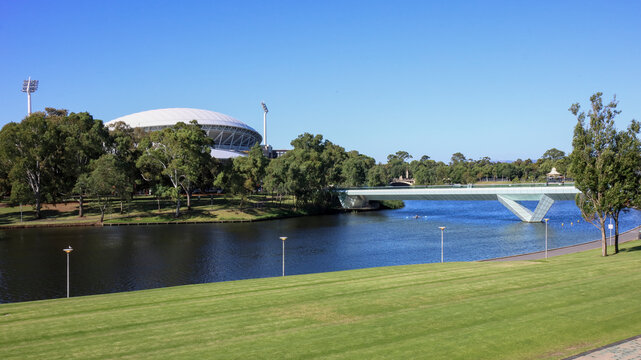 Adelaide, South Australia, Australia - December 11 2024: Scenic view, modern pedestrian bridge crossing the River Torrens toward iconic Adelaide Oval stadium. Riverbank Precinct, travel, tourism