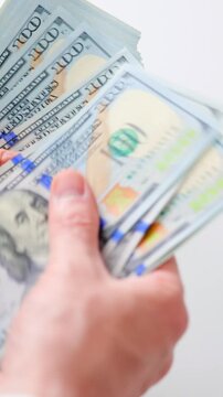 Male hands counting US Dollar bills, close-up