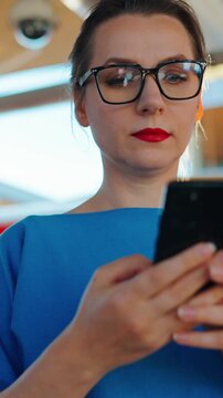 Woman stands at a transport stop and using smartphone. Slow motion