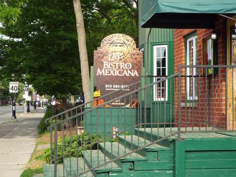 Gatineau,Quebec, Canada &ndash; June 4, 2026: The restaurant exterior features a prominent "129 Bistro Mexicana" sign near green wooden steps and a sidewalk along the streetat 129 Rue Principale.
