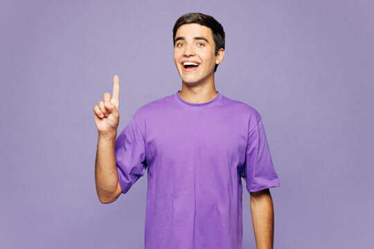 Young insighted smart proactive man wear violet t-shirt casual clothes holding index finger up with great new idea isolated on plain pastel light purple background studio portrait. Lifestyle concept.