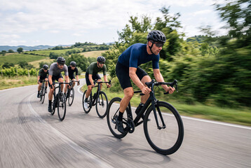 Fototapeta premium Group of Road Cyclists Racing Through Countryside