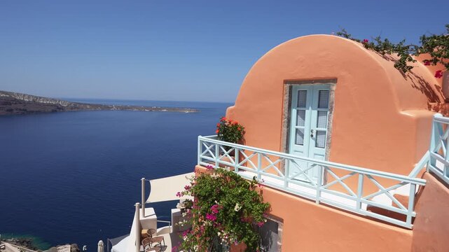 Santorini island, Greece. Colorful architecture with flowers in Oia town. Blue sea and the blue sky at sunny day. Travel and summer vacation concept. 

