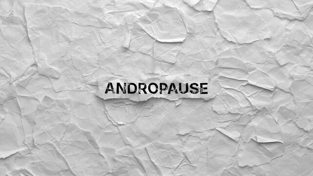 Crumpled piece of paper with word Andropause on torn crumpled white paper pieces background. Zoom in.