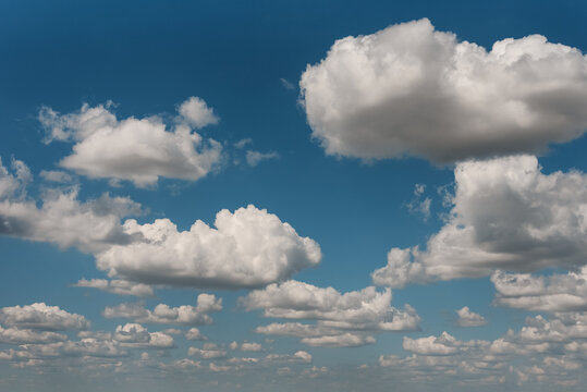 Beautiful cumulus clouds float across the blue sky