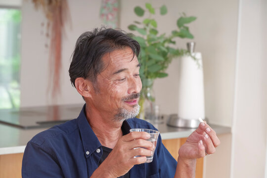内服薬を飲もうとするシニア男性