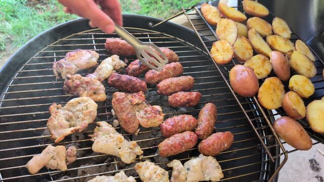 Close-up of outdoor barbecue with grilled chicken, cevapcici and fries, horizontal real time food video
