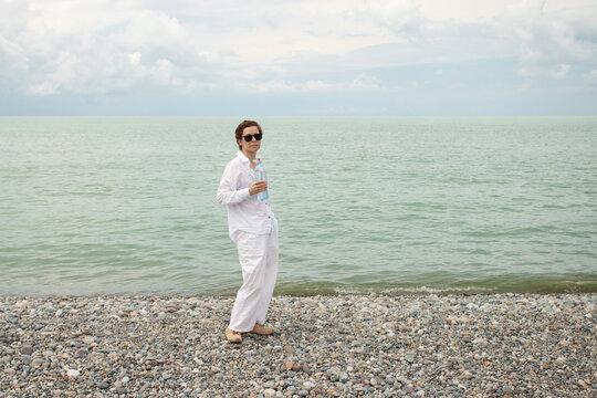 cancer survivor holds a bottle of water on the seashore, highlighting hydration during recovery, summer heat care and healthy rehabilitation after cancer treatment