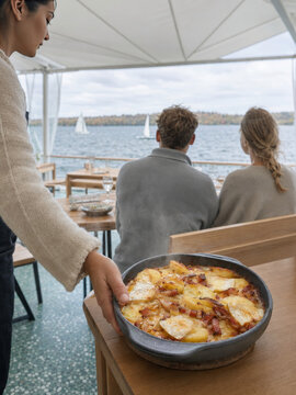 Comensales disfrutan de un platillo en un restaurante con vista al lago