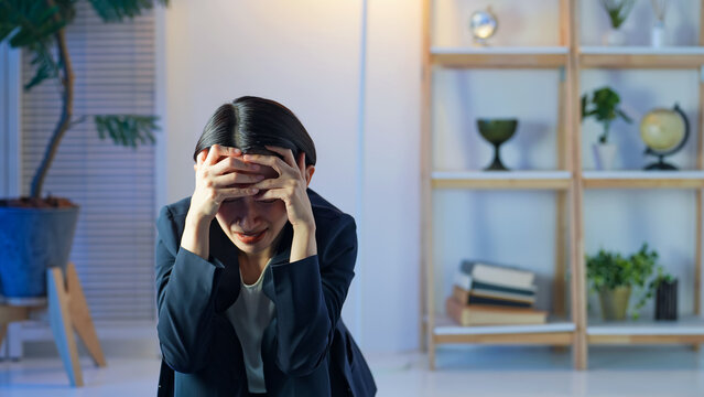 暗い部屋で落ち込むミドル女性。悩み、不安、心配、ストレス、うつ、絶望、メンタルヘルス、後悔、失敗