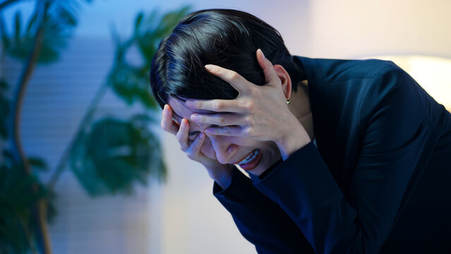 落ち込む女性ビジネスパーソン。ストレス、悩み、心配、不安、トラブル、暗い、疲労、孤独、しんどい