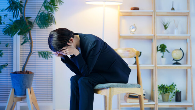 落ち込む女性ビジネスパーソン。ストレス、悩み、心配、不安、トラブル、暗い、疲労、孤独、しんどい