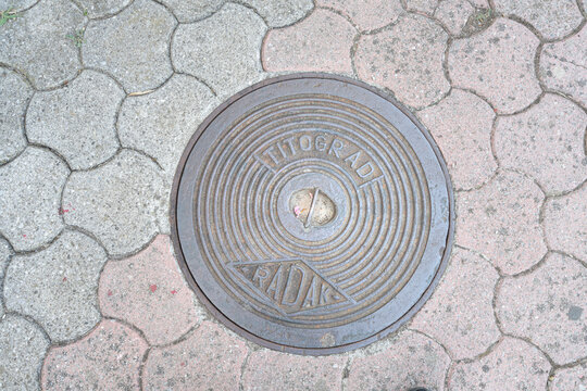 an old manhole with the former name of the city Titograd in Podgorica, Montenegro