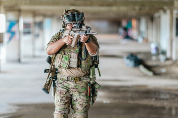 Fototapeta premium Military tactical operator holds rifle while clearing abandoned concrete building interior