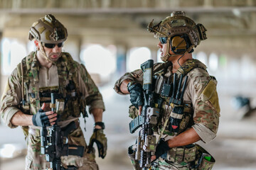 Fototapeta premium Military tactical operator holds rifle while clearing abandoned concrete building interior
