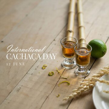 International cachaca day celebration concept with two glasses of spirit lime and bamboo on wooden table, brazilian