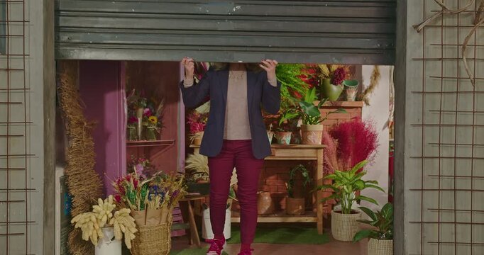 Female flower shop owner opens the storefront at the start of the day, showcasing entrepreneurship, neighborhood retail, fresh floral displays and authentic small business dedication