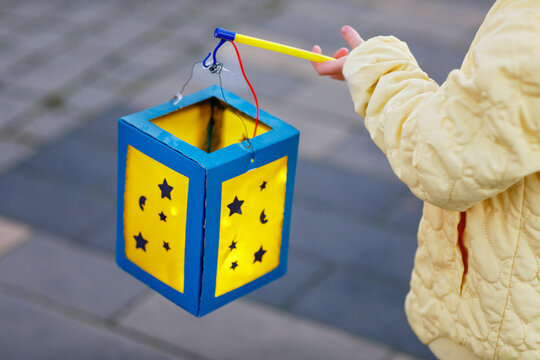 Closeup of little preschool kid girl holding selfmade traditional lanterns with candle for St. Martin procession. child happy about family parade in kindergarten. German tradition Martinsumzug