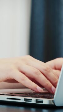 Fingers typing on keyboard, extra close up. Hands of young caucasian female typing on laptop keyboard. Vertical video