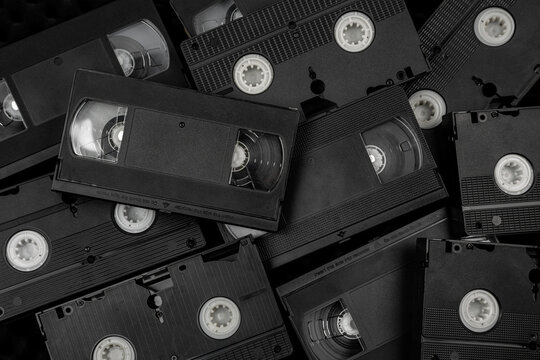 Pile of old black VHS cassette tapes back