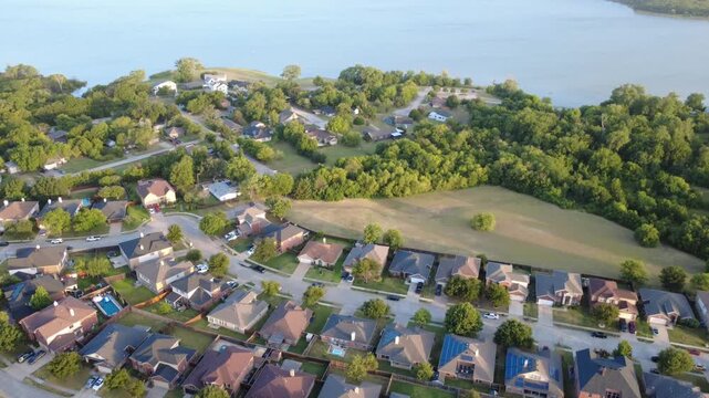 Private swimming pools punctuate residential lawns bordering natural tree belts near Lewisville Lake in Lakewood Estates. Modern suburban lifestyle infrastructure documents in Little Elm, DFW