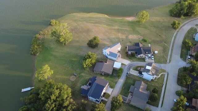 Lewisville Lake horizons frame densely clustered suburban rooftops in growing residential developments inside Lakewood Estates. Northern TX municipal expansion patterns unfold at Little Elm, DFW