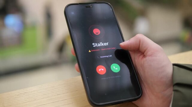 Smartphone displays a restricted caller warning during a disturbing call, reflecting stalking risks, cyber abuse and modern concerns about digital security.