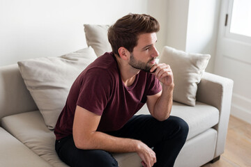 Fototapeta premium Pensive man sitting on sofa.