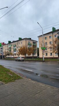 Gray day in a city with low clouds and buildings near the road