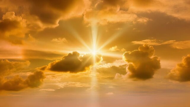Golden sunset sky with bright sun rays and fluffy clouds creating a warm peaceful atmosphere