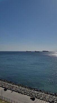 View of ships on water from shore during daytime