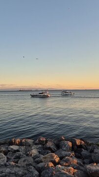 Boat sailing on calm waters during sunset near the coastline