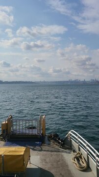 View from a boat on the water with city skyline in the distance on a clear day