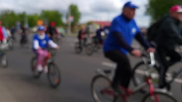 Bikers ride together on a street in a busy area during an afternoon event