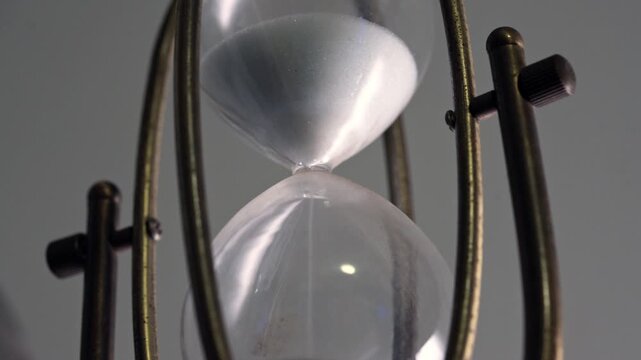 Closeup Vintage Hourglass White Sand Timer with Brass Frame Measuring Time Passage
