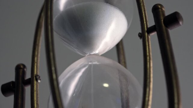 Closeup Vintage Hourglass White Sand Timer with Brass Frame Measuring Time Passage