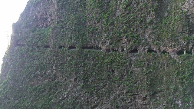 Aerial drone pan left shot revealing the breathtaking, remote mountain path of "Las Ventanas de G&uuml;&iacute;mar" carved into the rugged cliff face of Monta&ntilde;a Pinocho on Tenerife, Canary Islands.